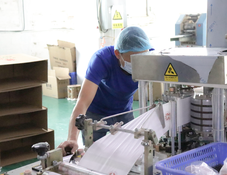 travailleur de contrôle de qualité inspectant le processus de production de papier toilette